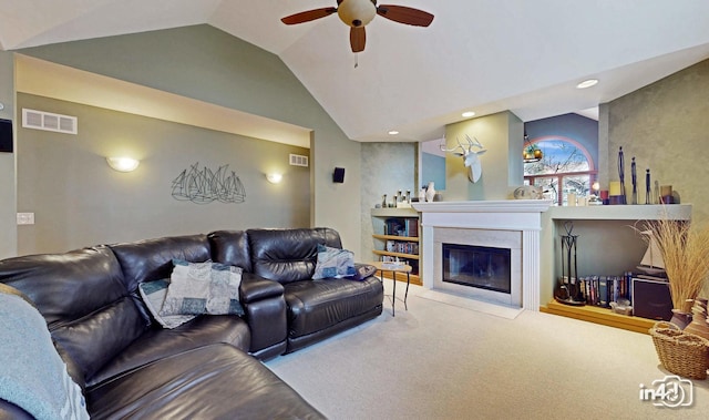 living room featuring vaulted ceiling, carpet, ceiling fan, a premium fireplace, and visible vents