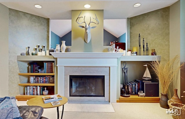 carpeted living area with a tile fireplace and recessed lighting