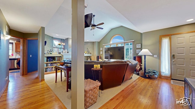 living room with a wealth of natural light, a ceiling fan, light wood finished floors, and lofted ceiling