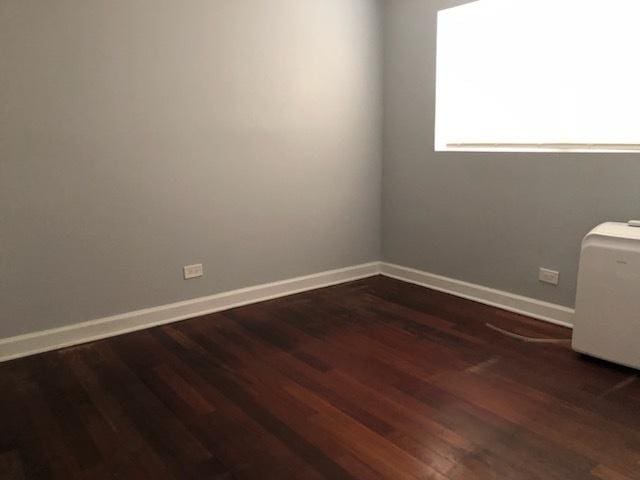 1937 W Pratt Ave Unit 1N, Chicago, IL 60626 - empty room featuring dark wood-style flooring and baseboards