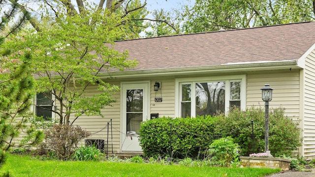 property entrance featuring a shingled roof