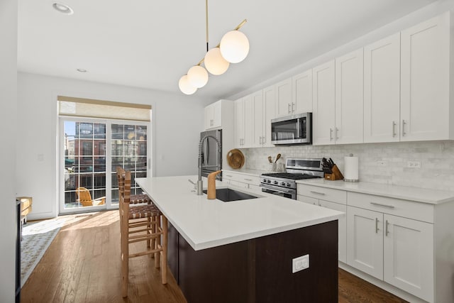 1020 Cedar Ct, Oak Park, IL 60302 - kitchen with dark wood-style floors, backsplash, a kitchen island with sink, stainless steel appliances, and a sink