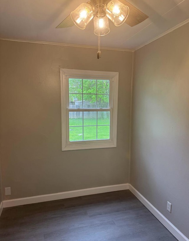 unfurnished room with crown molding, baseboards, ceiling fan, and dark wood-style flooring