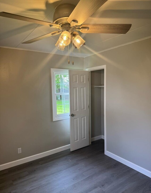 1057 Eastview Dr, Rantoul, IL 61866 - unfurnished bedroom with baseboards, ornamental molding, dark wood-style floors, a ceiling fan, and a closet