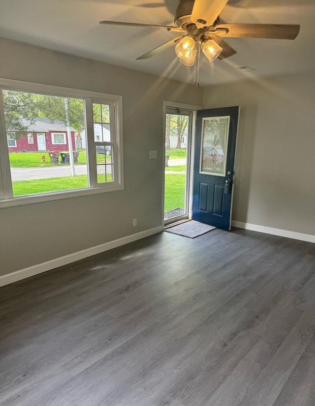 foyer with baseboards, a ceiling fan, and a wealth of natural light