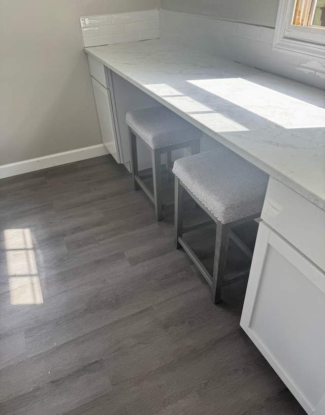 dining space featuring baseboards and dark wood finished floors