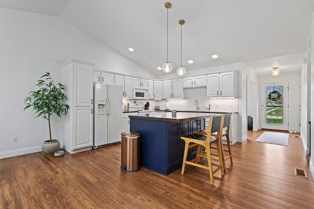 1318 Ridge Pointe Dr, Monticello, IL 61856 - kitchen with a center island, vaulted ceiling, visible vents, white cabinetry, and white appliances
