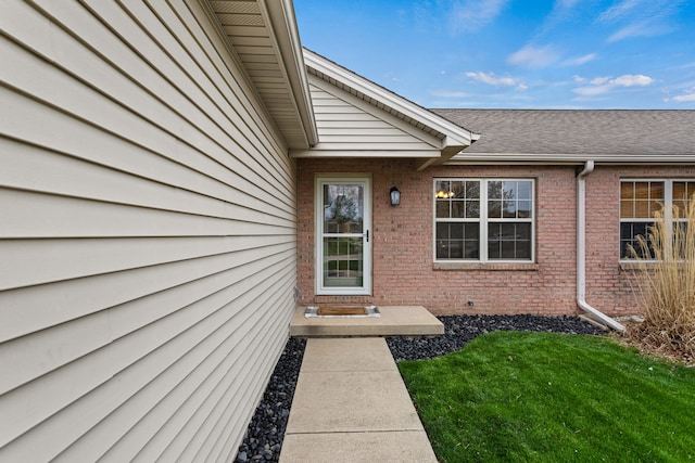 1318 Ridge Pointe Dr, Monticello, IL 61856 - view of exterior entry featuring brick siding and a yard