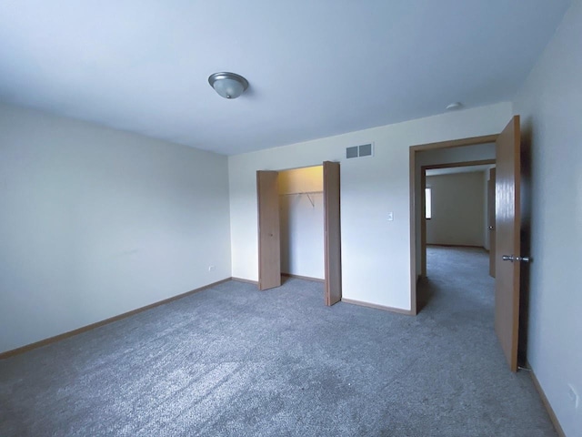 unfurnished bedroom with carpet floors, a closet, visible vents, and baseboards
