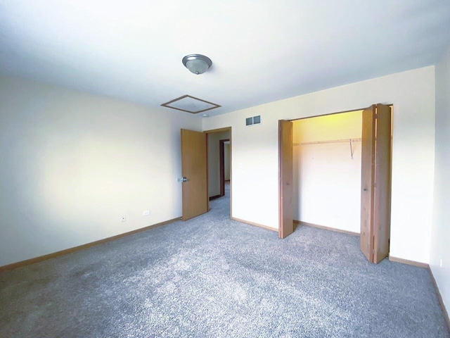 unfurnished bedroom with a closet, visible vents, carpet flooring, and baseboards