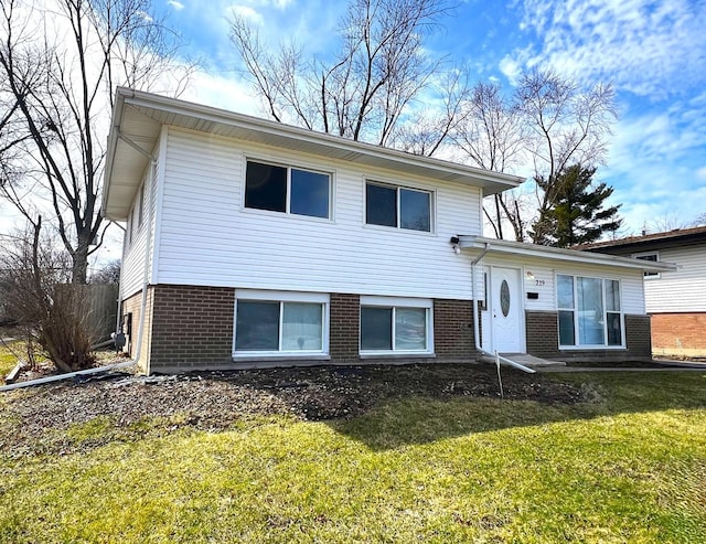 split level home featuring brick siding and a front yard