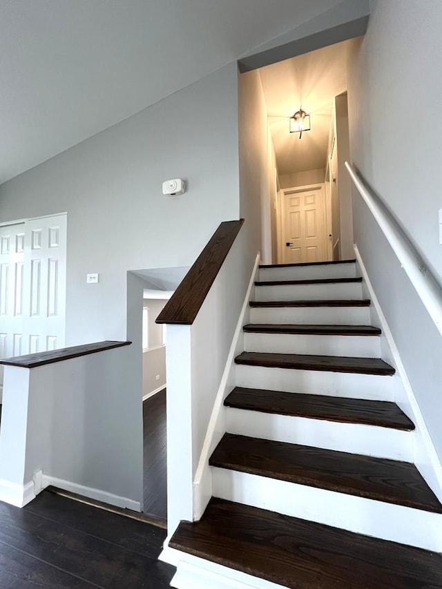 staircase featuring baseboards and wood finished floors
