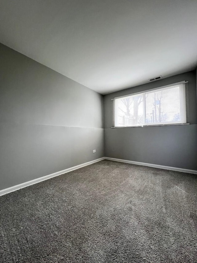spare room featuring visible vents, baseboards, and carpet flooring
