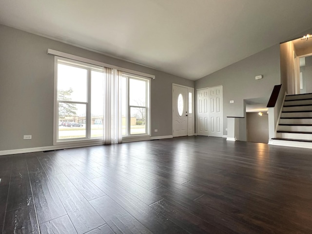 unfurnished living room featuring dark wood-type flooring, baseboards, vaulted ceiling, and stairs