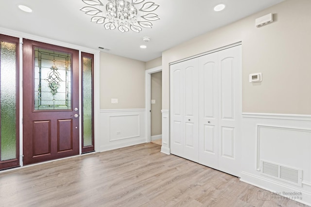 2015 N Woodlawn Park Ave, Mchenry, IL 60051 - entryway with light wood-style flooring, visible vents, an inviting chandelier, and wainscoting