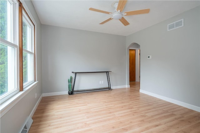 212 Keiser Ave, Normal, IL 61761 - unfurnished room featuring arched walkways, light wood finished floors, healthy amount of natural light, and a ceiling fan