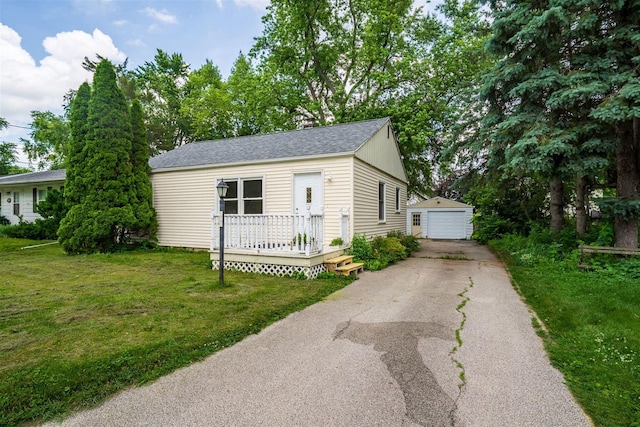 212 Keiser Ave, Normal, IL 61761 - view of front of house with an outbuilding, a detached garage, a front lawn, a wooden deck, and roof with shingles