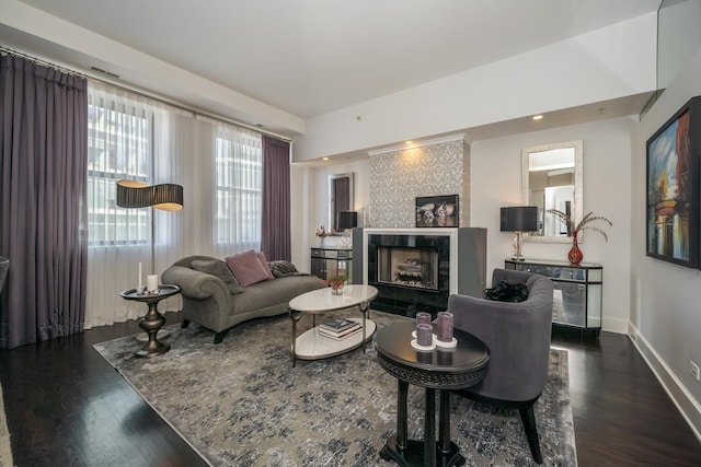 living room featuring dark wood finished floors, baseboards, and a tiled fireplace