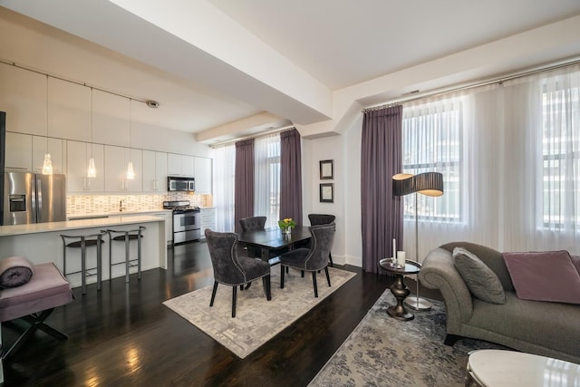 dining room with dark wood-style floors, plenty of natural light, and baseboards