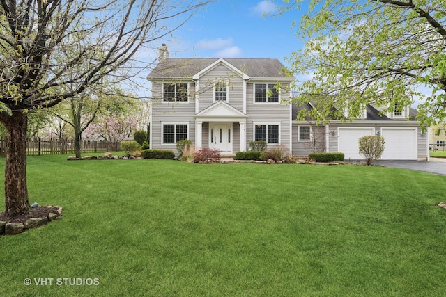 3625 Johns Manville Ave, Gurnee, IL 60031 - colonial home featuring driveway, a chimney, a garage, fence, and a front lawn