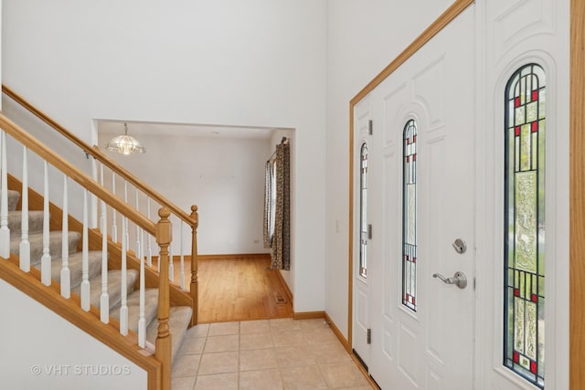 3625 Johns Manville Ave, Gurnee, IL 60031 - entryway with light tile patterned floors, baseboards, stairs, and a chandelier