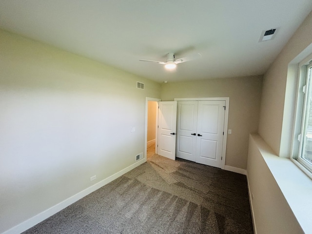 unfurnished bedroom with carpet, a ceiling fan, a closet, and baseboards