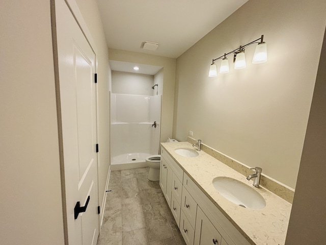 bathroom with a shower stall, toilet, and double vanity