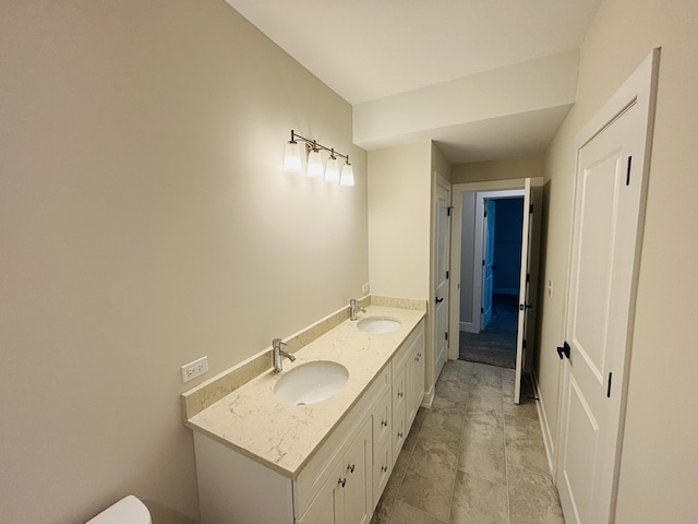 bathroom with double vanity and toilet