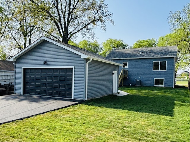 view of property exterior with a detached garage, a yard, an outbuilding, and central AC