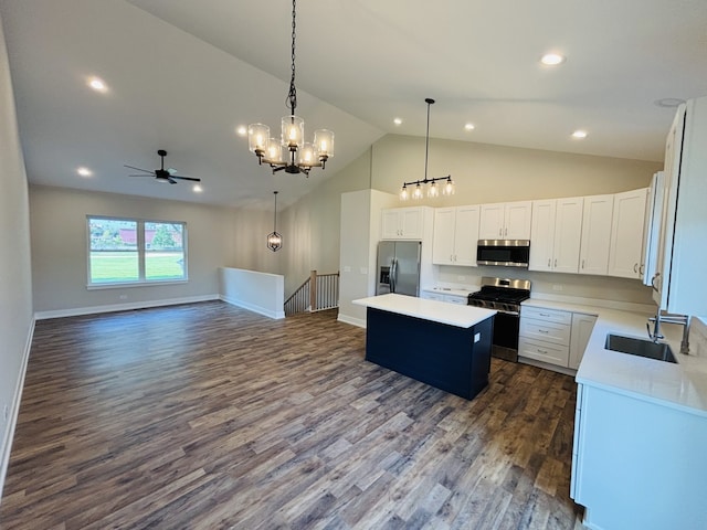 kitchen with appliances with stainless steel finishes, a sink, a center island, open floor plan, and a ceiling fan