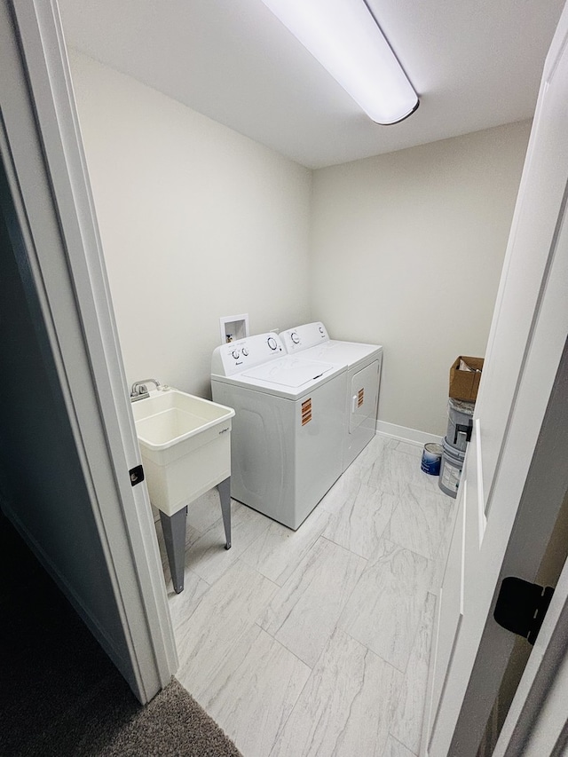 laundry area with washer and clothes dryer and light marble finish floors