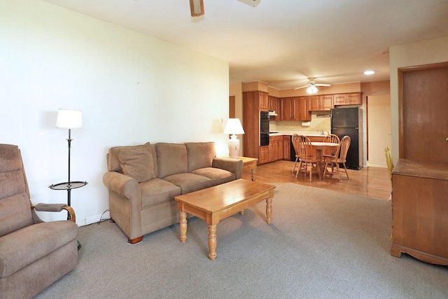 living area featuring baseboards, recessed lighting, light colored carpet, and a ceiling fan