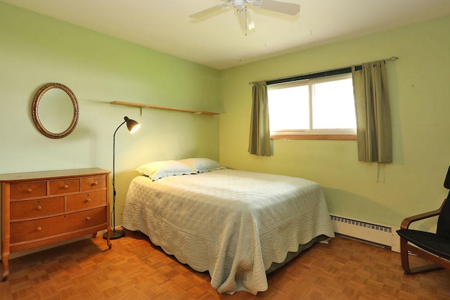 bedroom with a ceiling fan and baseboard heating