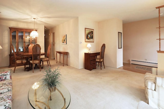 living room with a chandelier, carpet flooring, and a baseboard heating unit