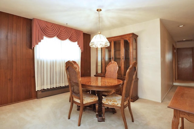 dining area featuring light colored carpet, a baseboard heating unit, a notable chandelier, and baseboards