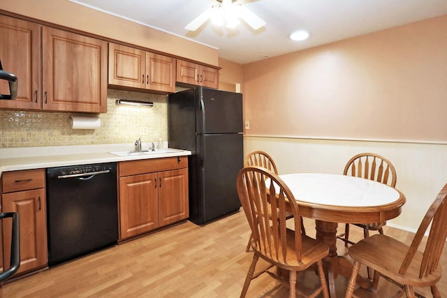 kitchen featuring a ceiling fan, black appliances, brown cabinets, decorative backsplash, and a sink