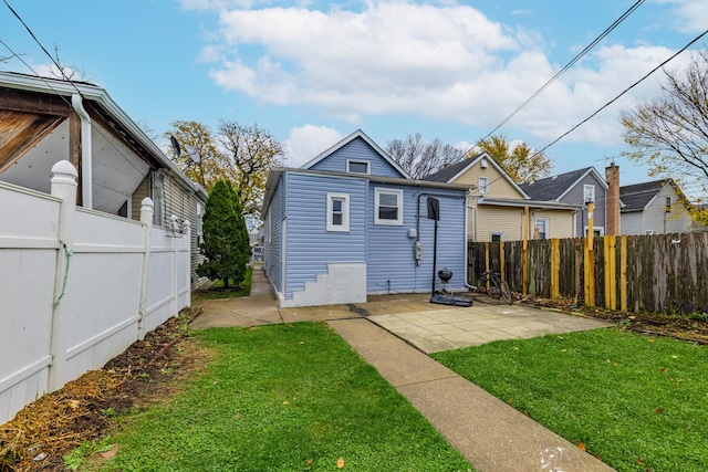 back of property featuring a patio, fence, and a lawn