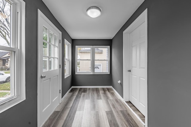 doorway featuring baseboards and wood finished floors
