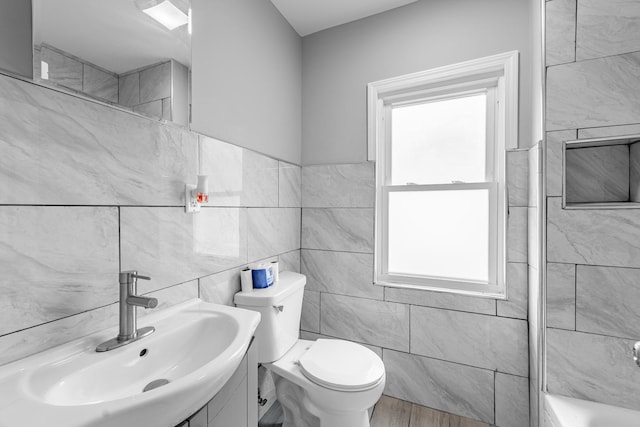 full bathroom with toilet, tile walls, plenty of natural light, and wood finished floors