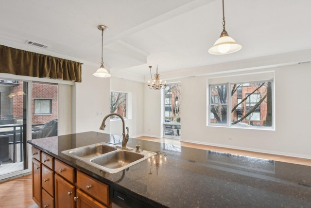 2317 W Wolfram St Unit 211, Chicago, IL 60618 - kitchen with a sink, crown molding, pendant lighting, brown cabinetry, and a chandelier