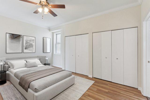 2317 W Wolfram St Unit 211, Chicago, IL 60618 - bedroom with multiple closets, ornamental molding, light wood-style flooring, and ceiling fan