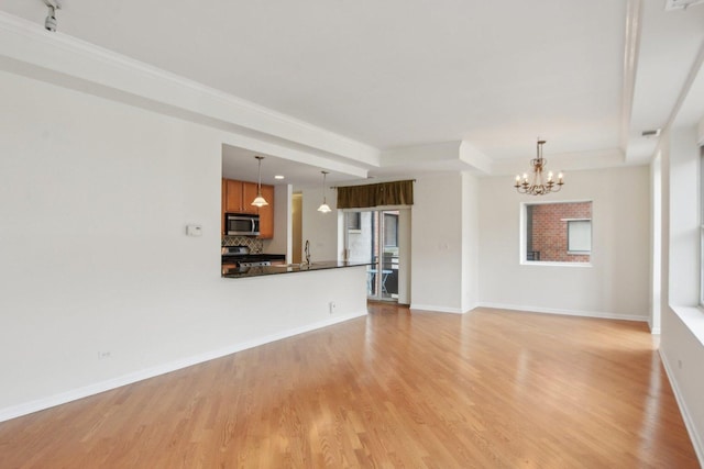 2317 W Wolfram St Unit 211, Chicago, IL 60618 - unfurnished living room with a sink, a chandelier, light wood-type flooring, and baseboards