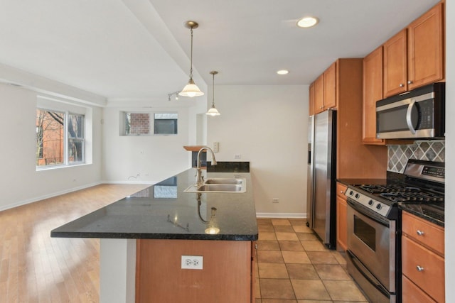 2317 W Wolfram St Unit 211, Chicago, IL 60618 - kitchen with appliances with stainless steel finishes, a sink, baseboards, decorative backsplash, and brown cabinetry