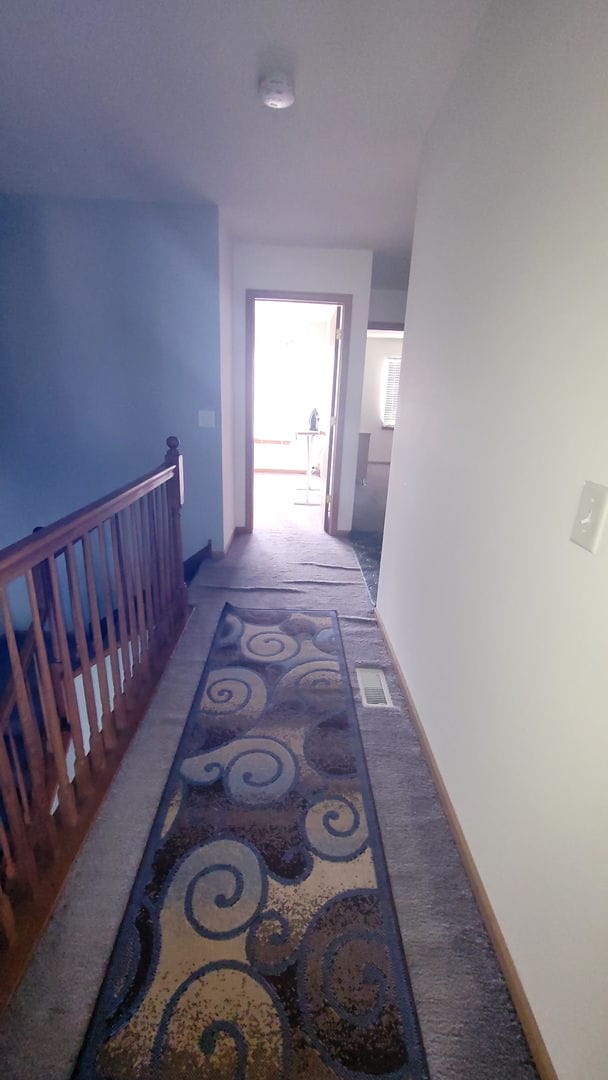 corridor featuring visible vents and an upstairs landing