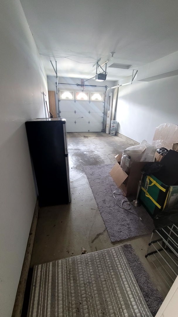 garage with freestanding refrigerator and a garage door opener
