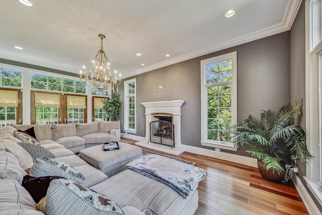 105 Fuller Rd, Hinsdale, IL 60521 - living area featuring baseboards, a fireplace with raised hearth, a notable chandelier, crown molding, and wood-type flooring
