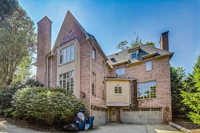 105 Fuller Rd, Hinsdale, IL 60521 - view of front facade featuring an attached garage, a chimney, driveway, and brick siding
