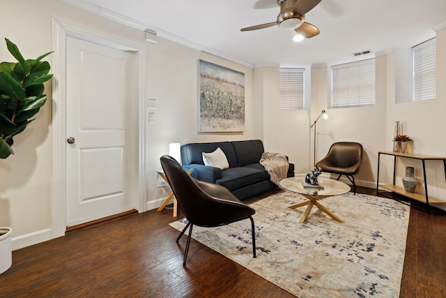 living room featuring wood finished floors, visible vents, ornamental molding, baseboards, and ceiling fan