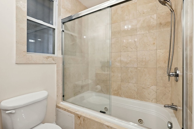 bathroom with toilet and a combined bath / shower with jetted tub