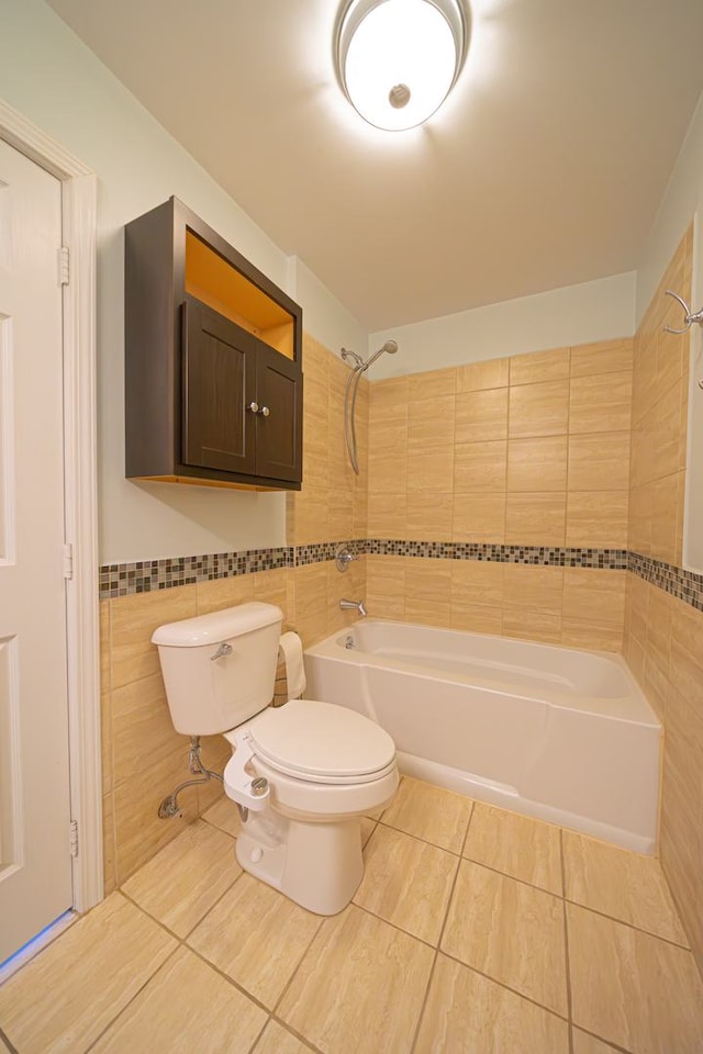 bathroom featuring washtub / shower combination, tile walls, tile patterned flooring, and toilet